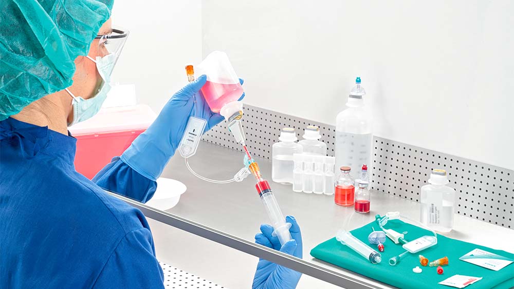 El farmacéutico extrae la jeringa bajo el flujo de aire laminar