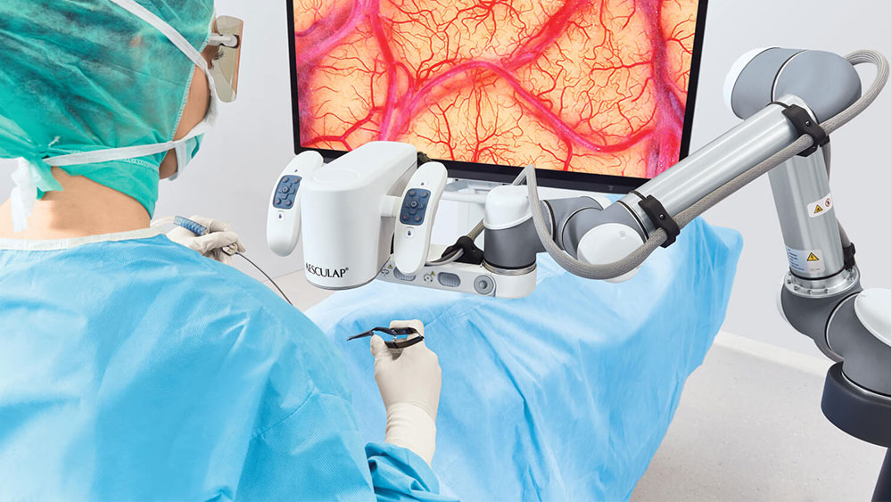 Un cirujano realiza una cirugía con el Aesculap Aeos® de pie y mirando el monitor. 
