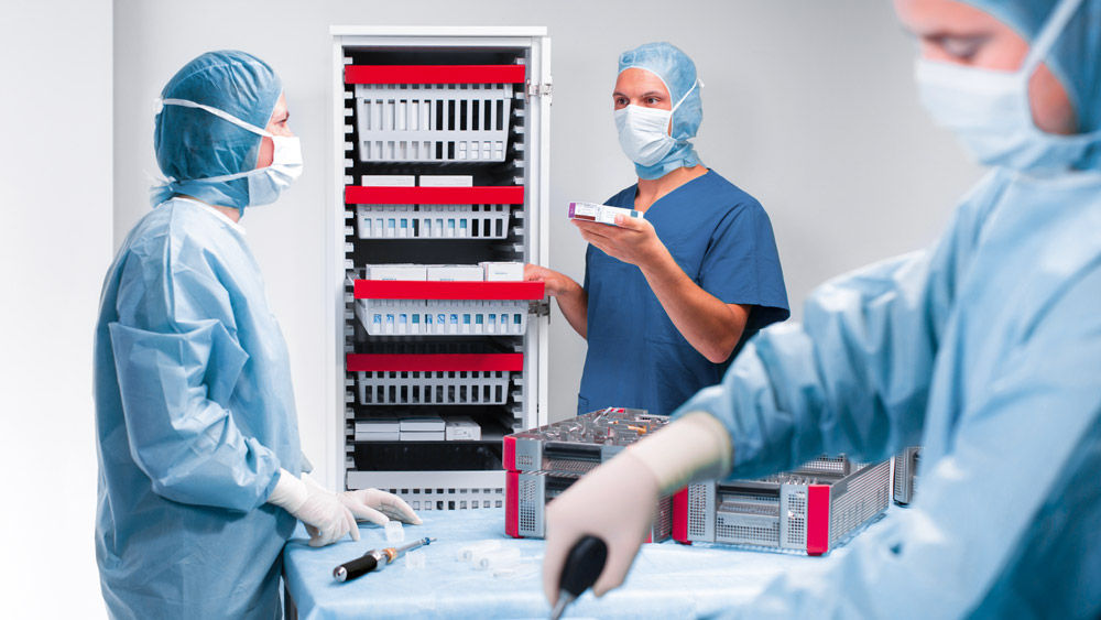 Tres cirujanos preparan el instrumental para una intervención quirúrgica