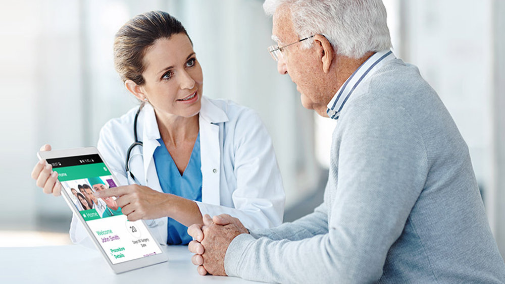 El médico explica la aplicación para pacientes a su paciente en una tableta