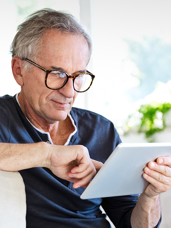 Hombre con gafas mirando una tableta en sus manos