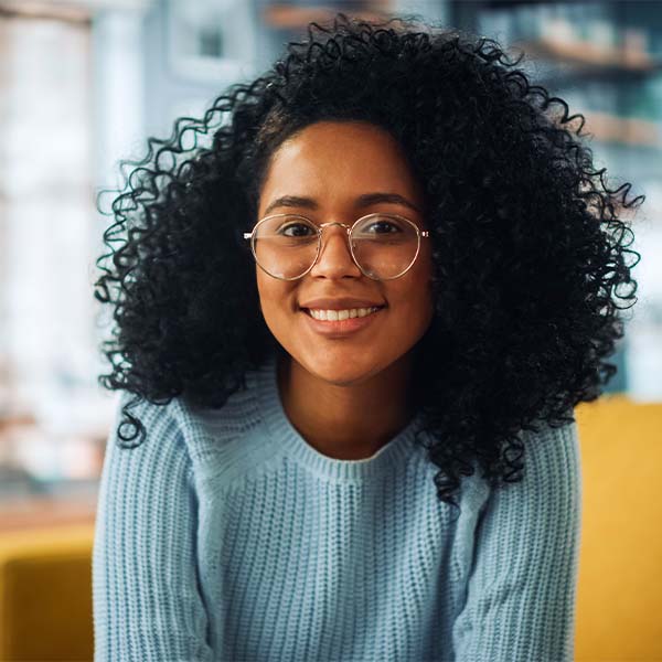 Una persona que lleva gafas sobre un fondo verde y que irradia confianza e inteligencia. 